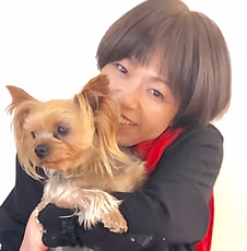 犬を抱いて微笑む美容師の阪本浩子